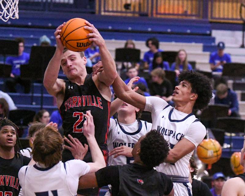 Yorkville's Taelor Clements, left, gets a rebound while being defended by Oswego East's Jacsen Tucker during the game on Friday Feb. 14, 2025, held at Oswego East High School.