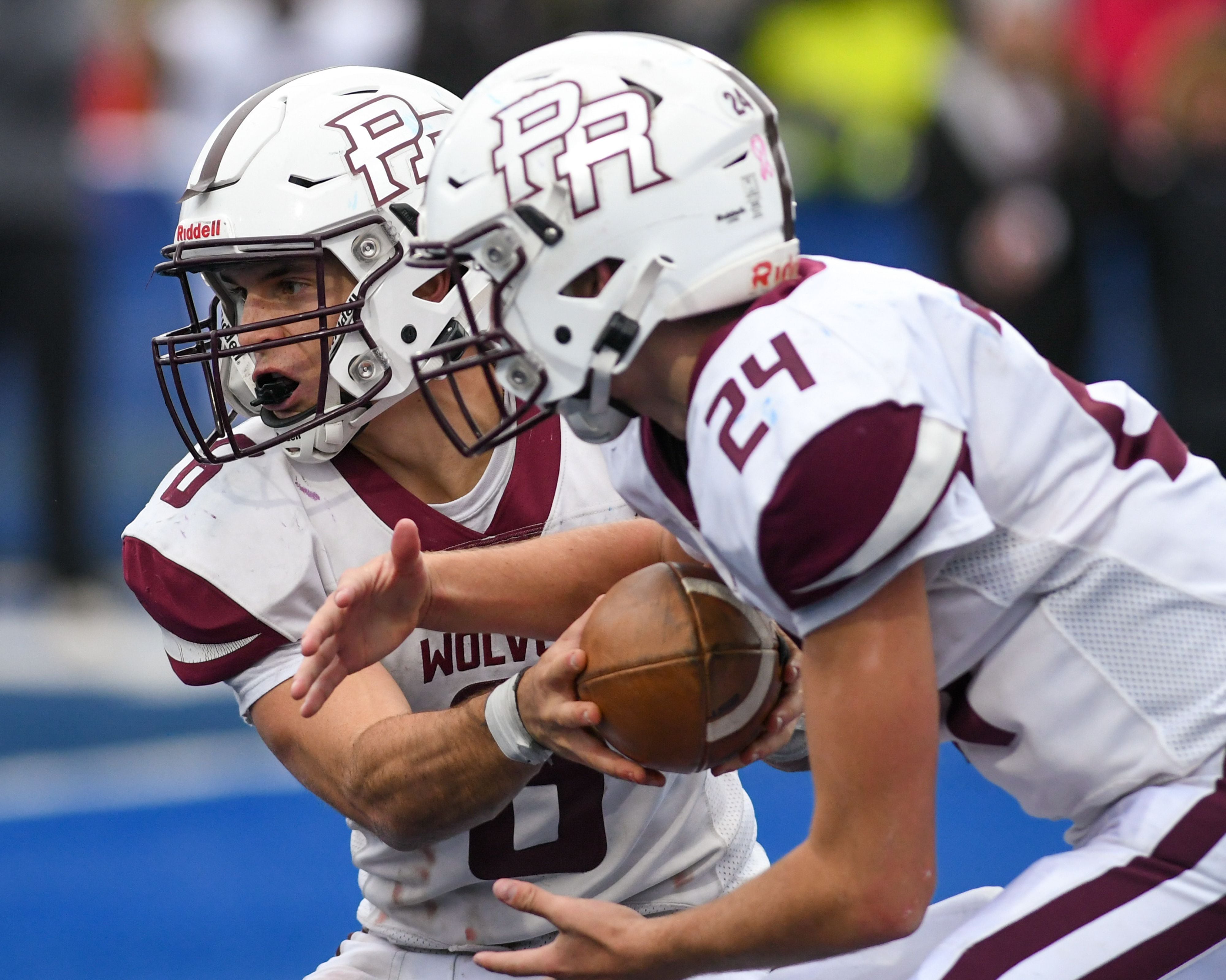 Prairie Ridge's Luke Vanderwiel (6) hands the ball off to teammate Vincent Byk (24) while traveling to take on St. Francis in the second round 5A game on Saturday Nov. 8, 2025, held at St. Francis's High School.