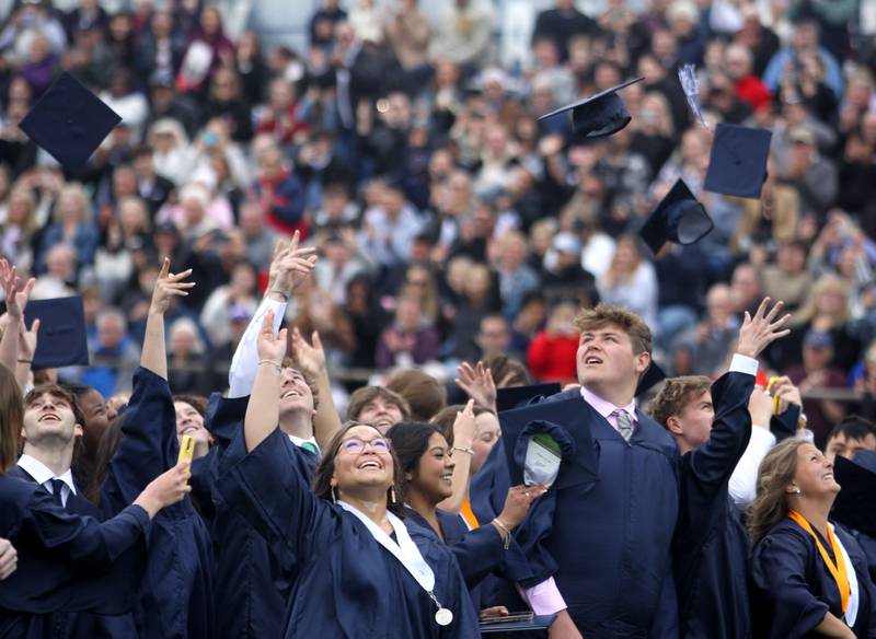 Members of the Class of 2025 toss their caps into a stiff wind to conclude graduation at Cary-Grove High School in Cary on Saturday, May 17, 2025.