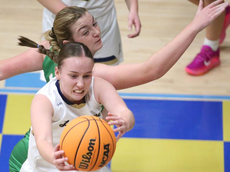 Marquette's Chloe Larson grabs a rebound over Seneca's Tella Krull on Thursday, Dec. 5, 2024 in Bader Gym at Marquette High School.