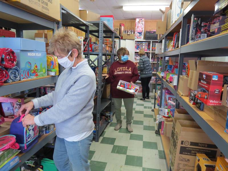 Karen Ossola (from left), Cathy Oliveri (center) and Brenda Bartoluzzi restock the shelves with toys in preparation for the 2021 Toys in the Pantry event.