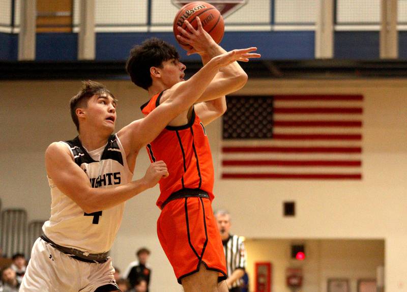 McHenry’s Marko Visnjevac takes a shot as Kaneland’s Preston Popovich, left, defends in Hoops for Healing basketball tournament championship game action at Woodstock Wednesday.