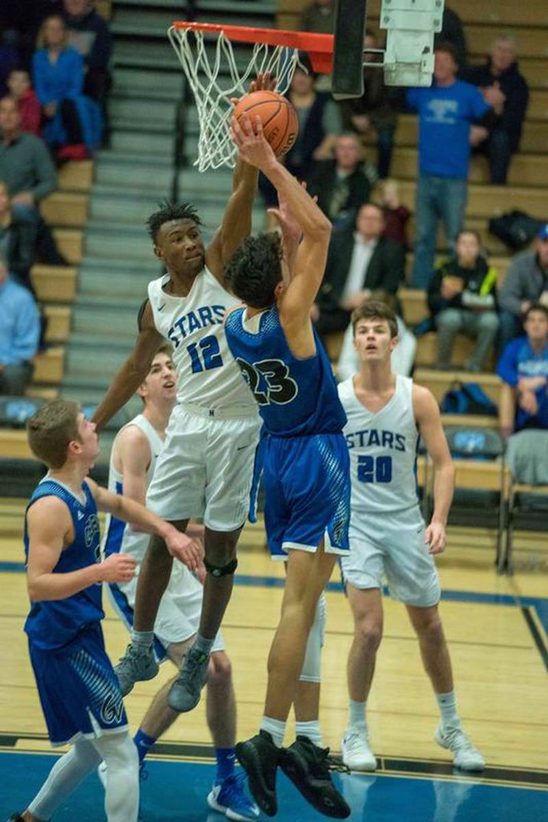 St. Charles North guard Tyler Nubin (12) blocks a shot against Geneva guard Nathaniel Santos (23) in St. Charles Feb. 2.