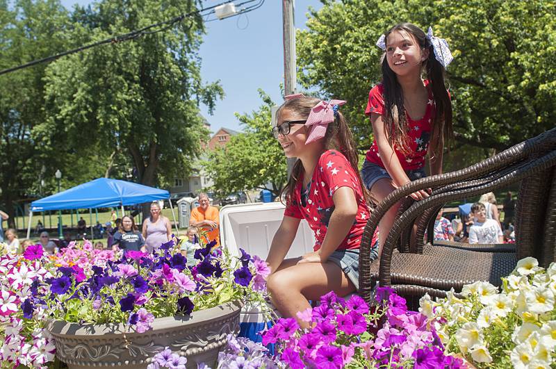 A pair of young girls ride the Work On It landscape float surrounded by the celebrated flower of Dixon Sunday, July 3, 2022.