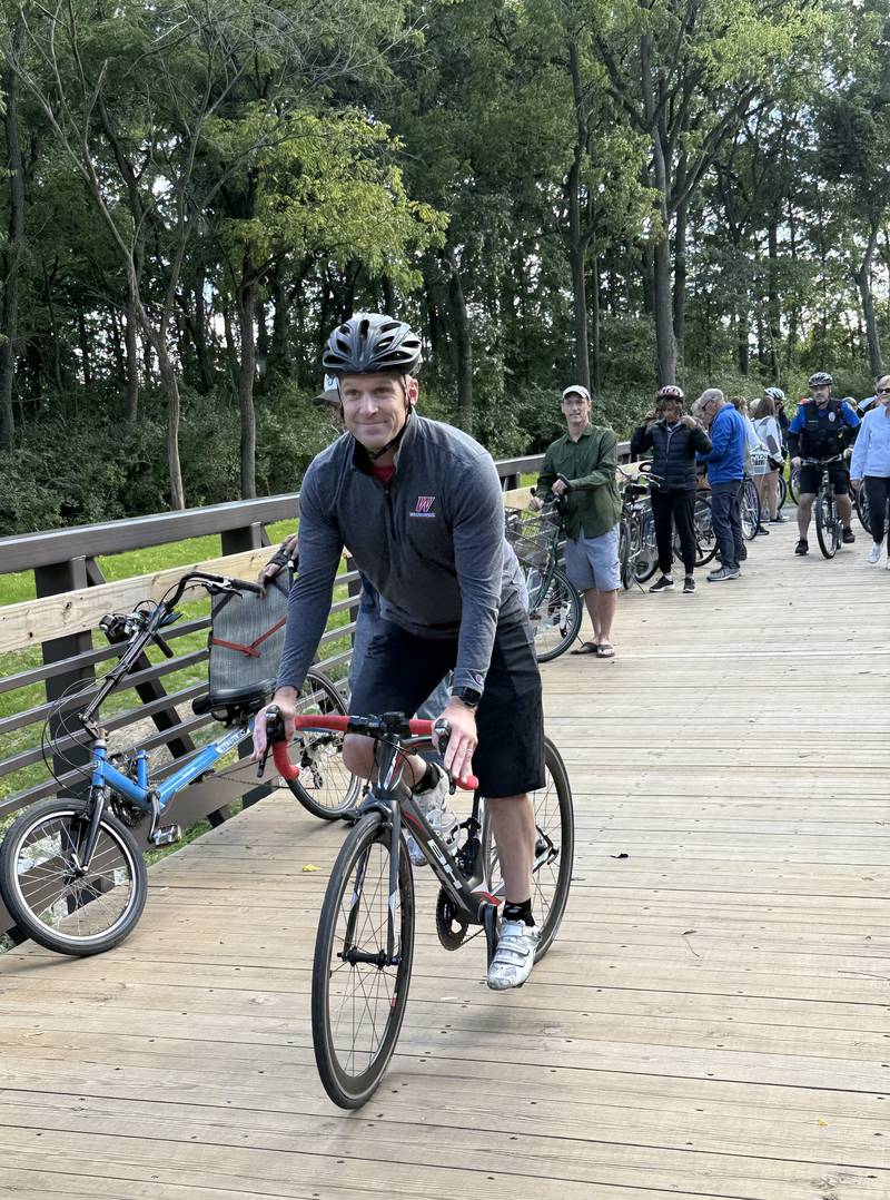 Waubonsee Community College President Brian Knetl participates in a community bike ride during a ribbon cutting for the Bridge at Belle Vue Park on Sept. 5, 2025, in Sugar Grove.
