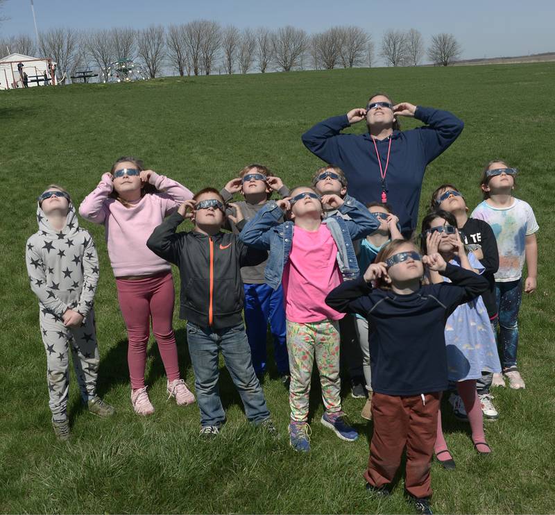 K-2nd grade students at Deer Park School gather on the grounds of the school to watch the eclipse at 2:00 pm Monday .