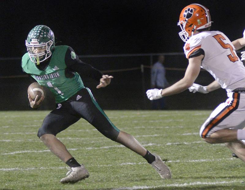 Seneca quarterback Nathan Grant runs to get by Byron’s Ashton Henkel on a keeper in the 1st quarter in the second round of the IHSA Class 3A football playoffs on Friday, Nov. 4, 2022 in Seneca.