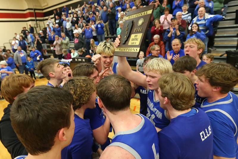 Members of the Princeton boys basketball team hoist the Class 2A Regional plaque after defeating Morrison during the Class 2A Regional final game on Friday, Feb. 23, 2024 at Erie-Prophetstown High School.
