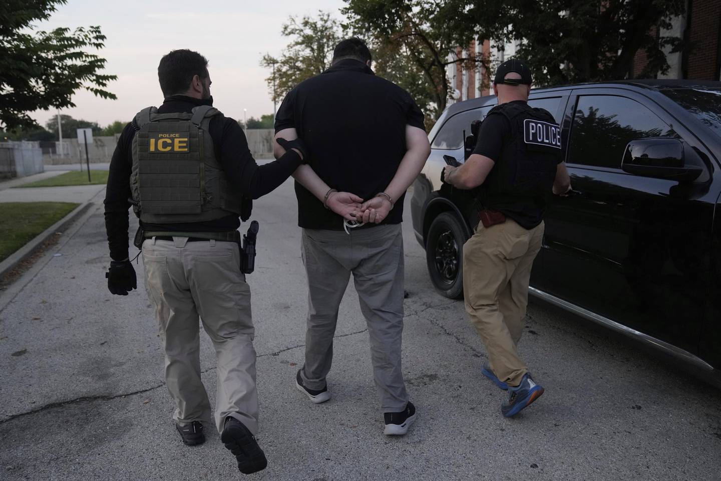 U.S. Immigration and Customs Enforcement agents make an arrest during an early morning operation in Park Ridge, Ill., Friday, Sept. 19, 2025. (AP Photo/Erin Hooley)