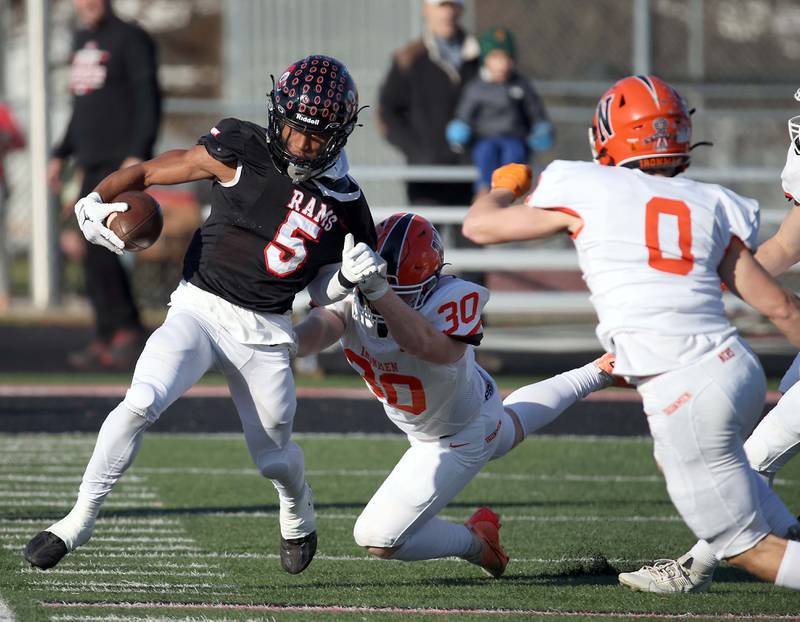Glenbard East's Amonte Cook (5) slips around Normal's Winton Carlock (30) during the IHSA Class 7A quarterfinals Saturday November 11, 2023 in Lombard.