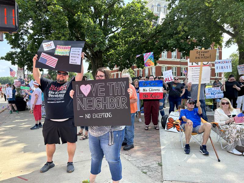 Attendees at the "No Kings" rally held in Oregon, Illinois on Saturday, June 14, 2025 hold their signs critical of the actions by President Donald Trump.