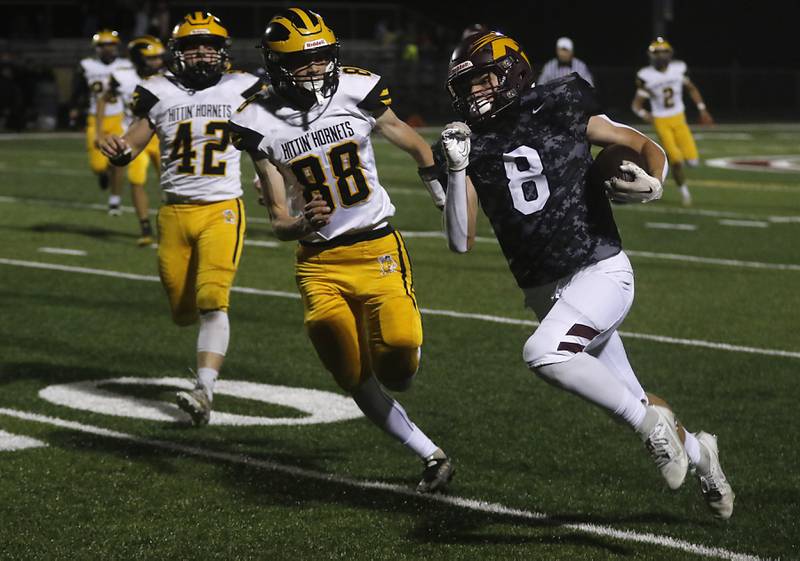 Richmond-Burton's Jack Martens runs for a touchdown as Harvard's Bernard Bahnsen tries to catch him during a Kishwaukee River Conference football game on Thursday, Oct.12, 2023, at Richmond-Burton High School.