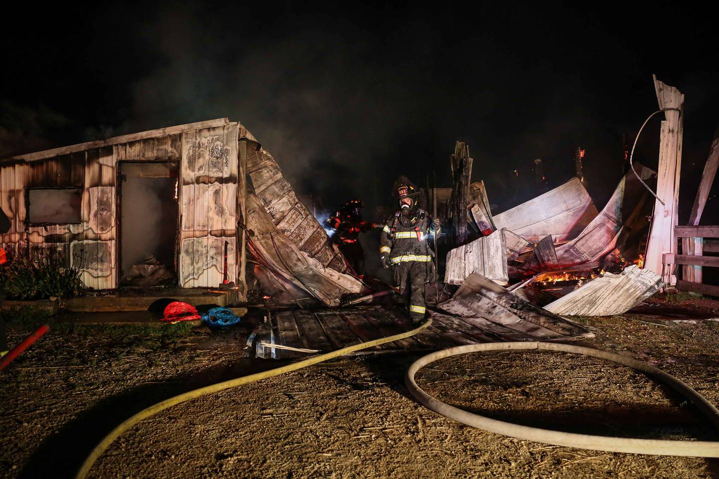 Firefighters battle a blaze at a barn near Harvard on June 9, 2025, that killed six horses.