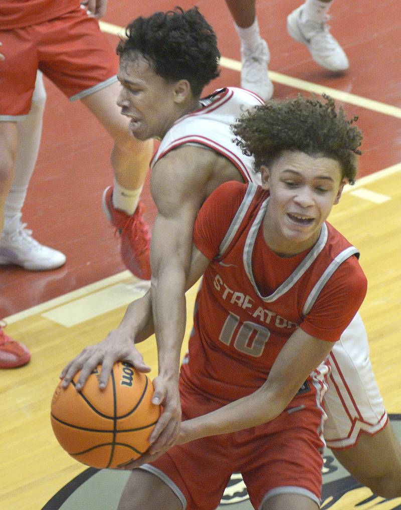 Streator’s Christian Bruton holds on to the ball as Ottawa’s Hezekiah Joachim tries to take it away in the 2nd period Saturday at Ottawa.