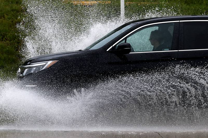 Vehicles navigate a section of high water on Illinois Route 14, near Nimco Drive, on Tuesday, June 25, 2024, after heavy rain from overnight thunderstorms.
