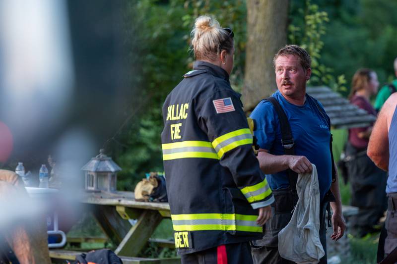 Firefighters talk whilst on scene on Saturday, July 19, 2025 at 2896 E 1380th Rd in Utica.