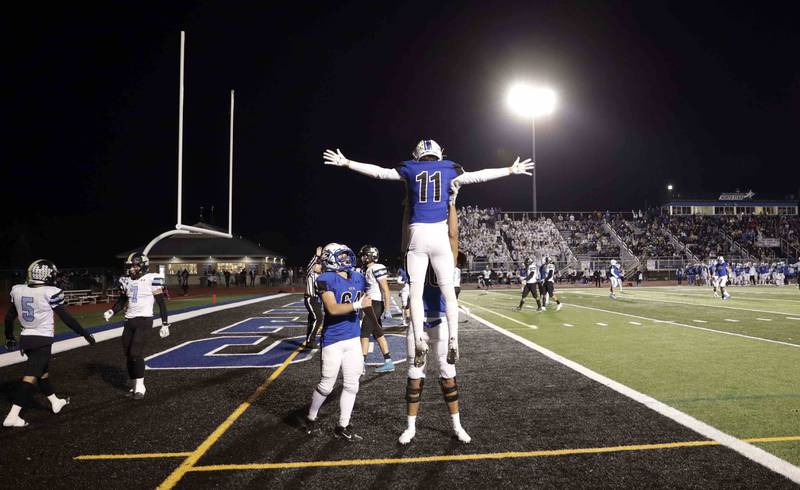 St. Charles North's Zach Priami (11) celebrates his touchdown with his teammates Friday October 28, 2022 in St. Charles.