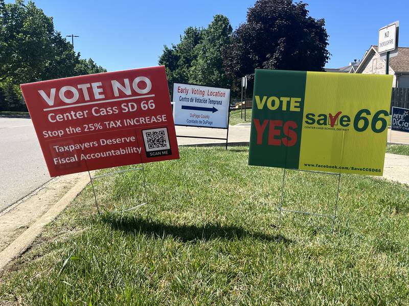Campaign signs supporting and opposing a referendum in Center Cass School District 66 appear outside an early voting location.