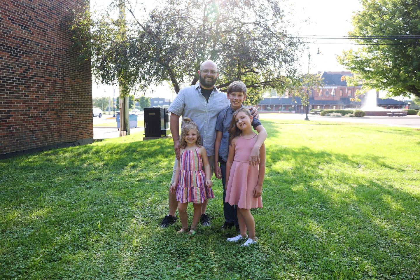 New York City Deli owner Stephen Girard, of Chebanse, stands with his three children, Kyler, 11, Scarlette, 7, and Sydney, 5, in the area where a new patio will sit adjacent to the deli's future second location in the 200 block of South Schuyler Avenue in the Standard Title building.