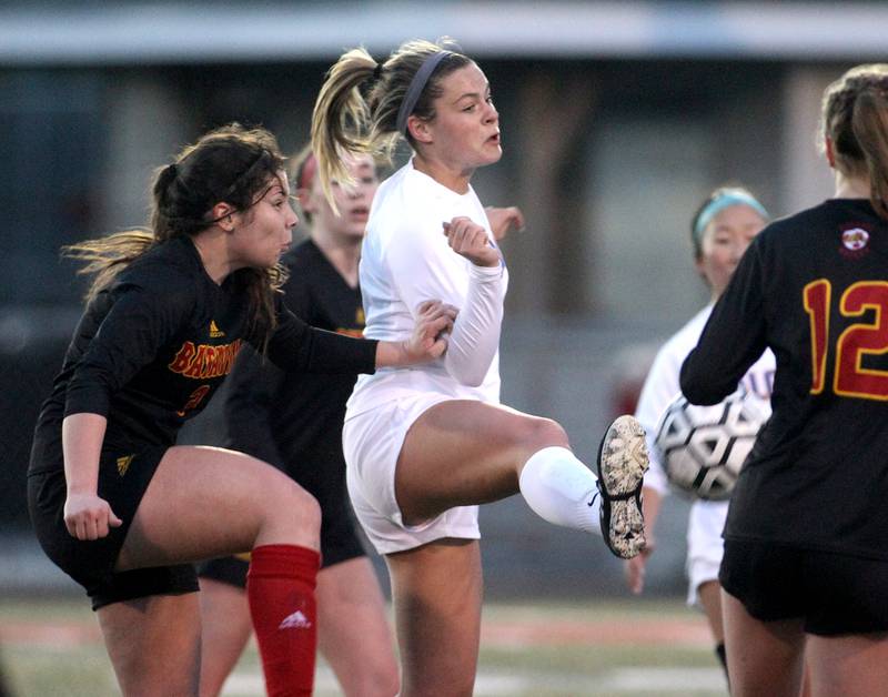 Wheaton North’s Grace Ryan (center) kicks the ball in the air during a game at Batavia on Thursday, April 7, 2022.