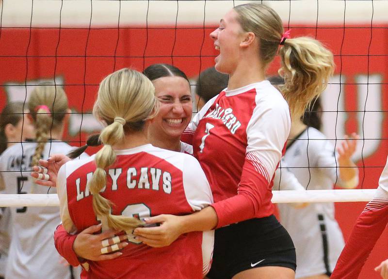 L-P volleyball players (from left) Anna Riva, Kelsey Frederick, and Aubrey Duttlinger react after getting a point against Kaneland on Tuesday, Oct. 7, 2025 in Sellett Gymnasium at L-P High School.