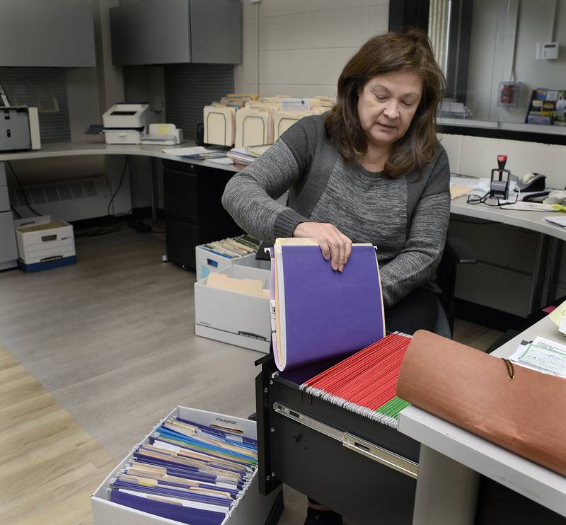 Almost moved in. Kathy Lewis of the Utica Village Clerk's Office empties file boxes to her desk cabinet as Utica completed Wednesday the move into the new village hall.
