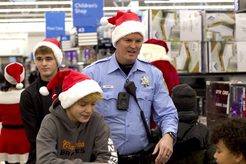 Joliet Police Officer Alan Vertin shops with children during the 36th annual Santa's Cops event on Saturday, Dec. 6, 2025, at Walmart, 401 Illinois Route 59, in  Shorewood.