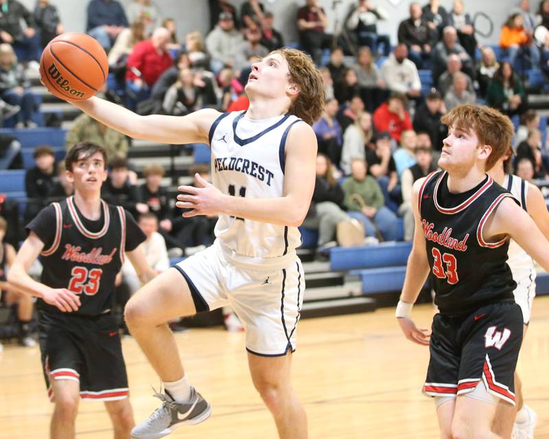 Fieldcrest's Nathan Cook drives to the hoop past Woodland's Kenny Eutsey on Tuesday, Dec. 19, 2023 at Fieldcrest High School.