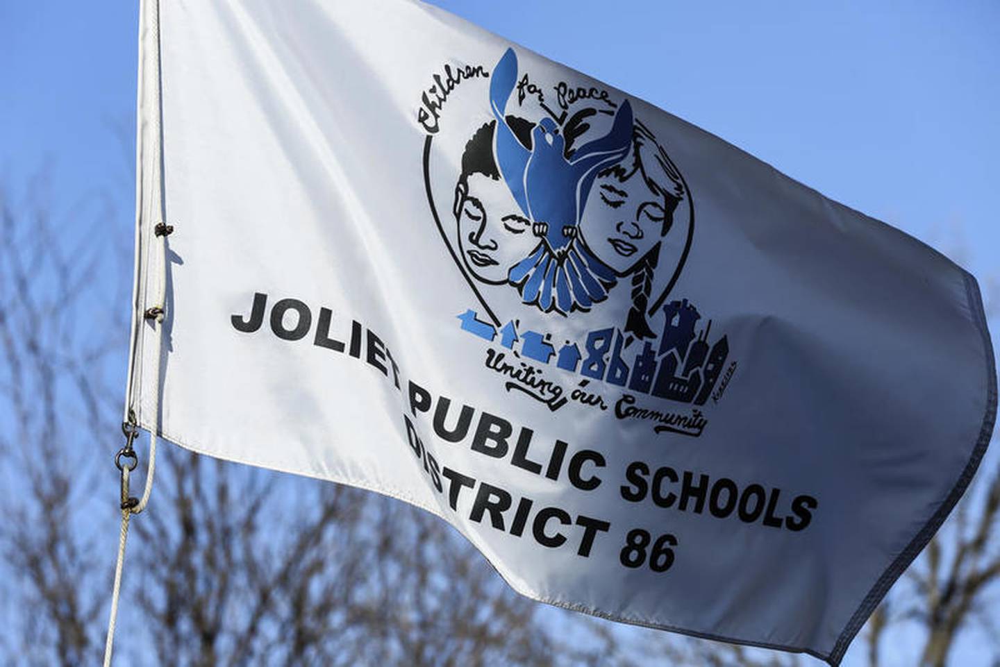 A Joliet Public School District 86 flag waves in the wind