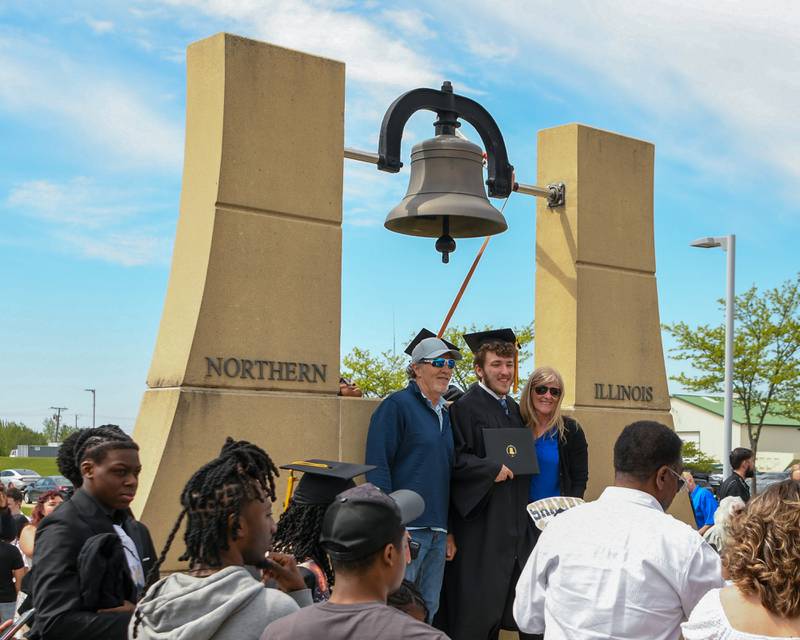 Northern Illinois University graduate Chase Richards, center, pose for a photo on Saturday May 9, 2026, with his parents Mick and Beth Richards after the graduation ceremony next to the bell outside the convocation center in DeKalb.