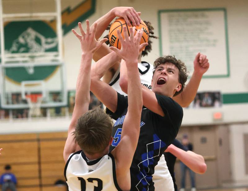 Woodstock's Maxwell Beard has his shot contested by Sycamore's Xander Lewis (front) and Sycamore's Josiah Mitchell Friday, Feb. 27, 2026, during their IHSA Class 3A boys basketball regional championship game at Boylan Catholic High School in Rockford.