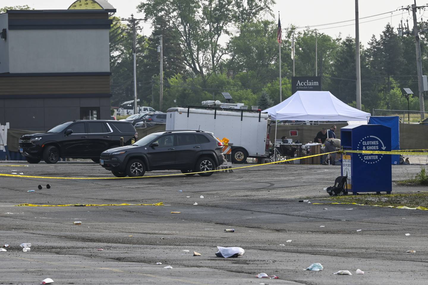 Investigators look over the scene of an overnight mass shooting at a strip mall in Willowbrook, Ill., Sunday, June 18.