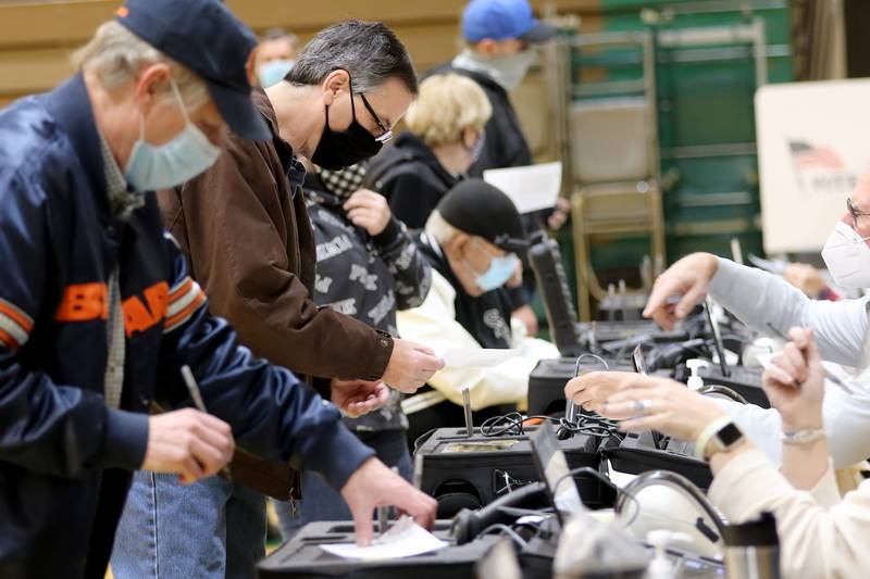 Voters check in with election judges at Crystal Lake South High School on Tuesday, Nov. 3, 2020 in Crystal Lake.