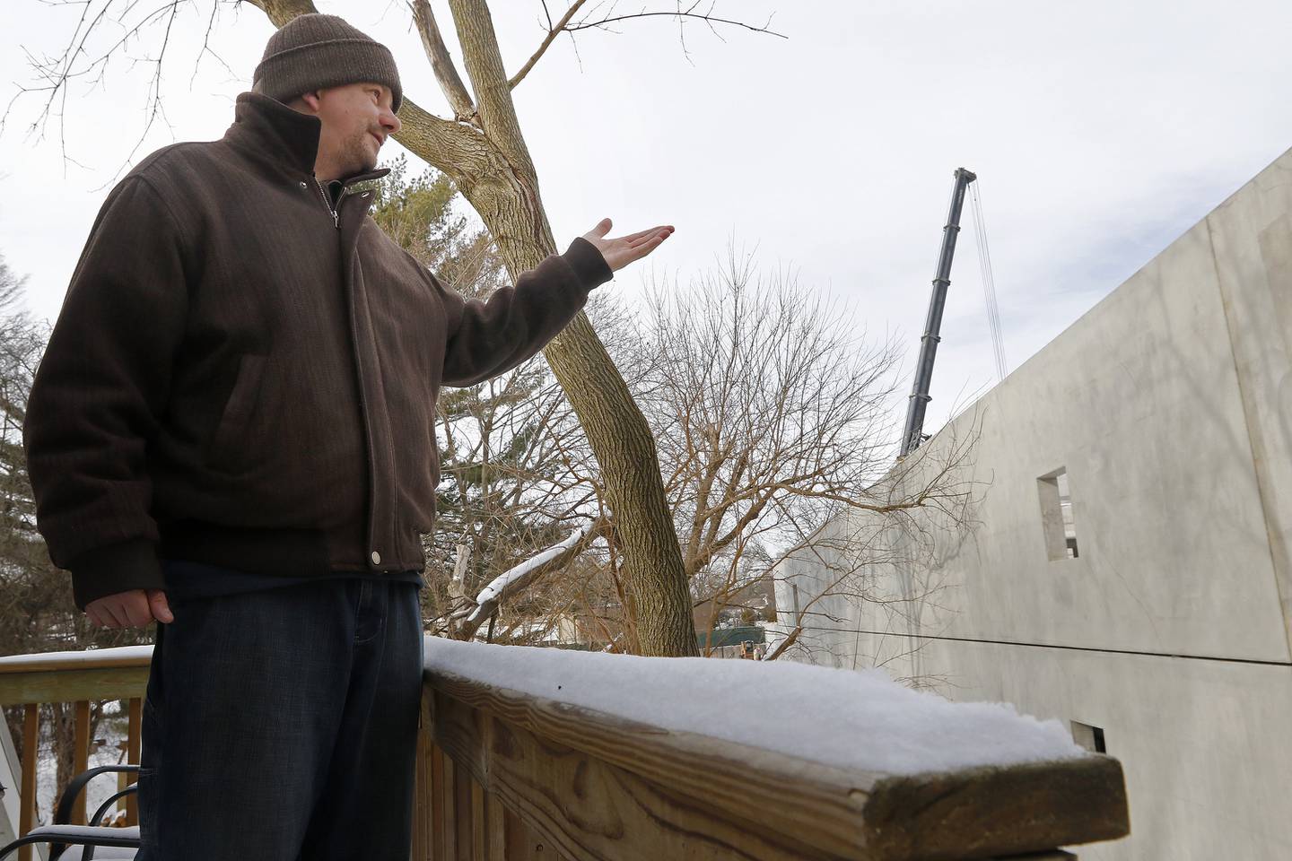 Bettendorf Castle resident Dan Strohl shows the construction cranes and parking structure seen from his neighbor's backyard Tuesday, Jan. 4, 2022, as he discusses the new apartment complex being built at the intersection of Algonquin Road and Northwest Highway in Fox River Grove.  The building was supposed to include a two-story underground parking deck and five residential floors above it, according to Bettendorf Castle resident William Strohl.