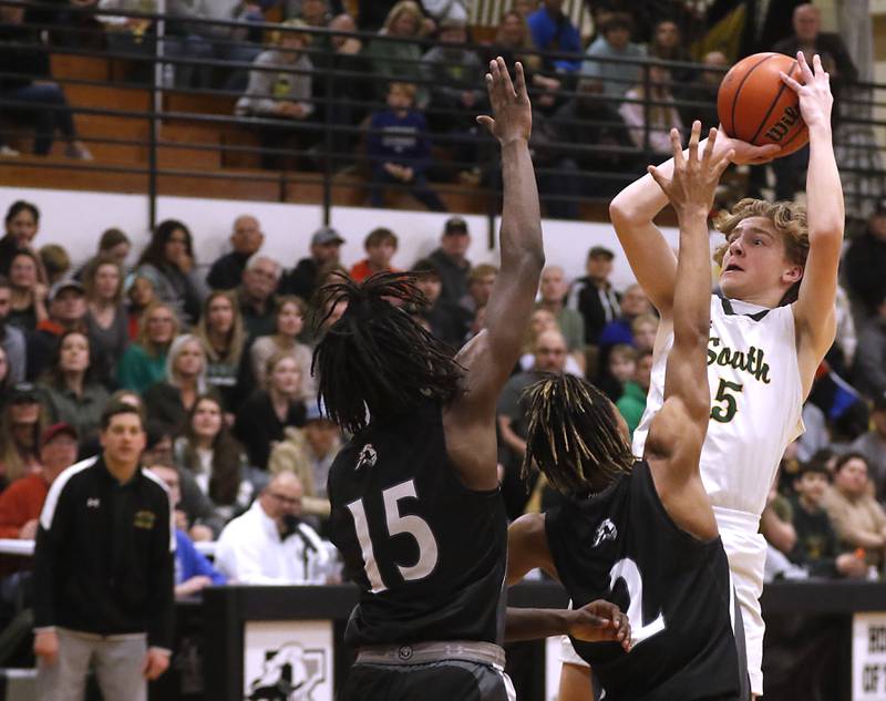 Crystal Lake South's Carson Trivellini shoots the ball over Kaneland's Evan Ross and Isaiah Gipson (center) during the IHSA Class 3A Kaneland Boys Basketball Sectional championship game on Friday, March 1, 2024, at Kaneland High School in Maple Park.