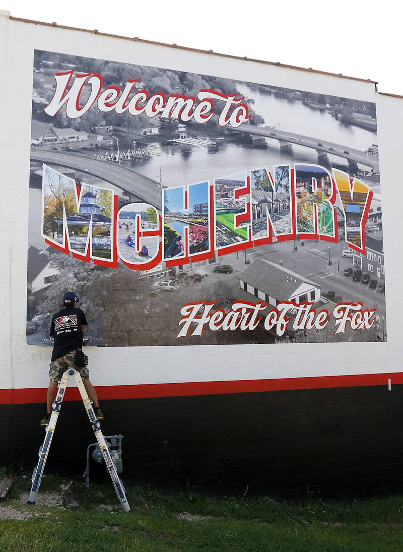 Chris Szymczuch, of Vindictive Vinyl, works on installing a vinyl mural on Thursday, June 19, 2025, on the side of a building at 3413 W. Elm St, in McHenry.
