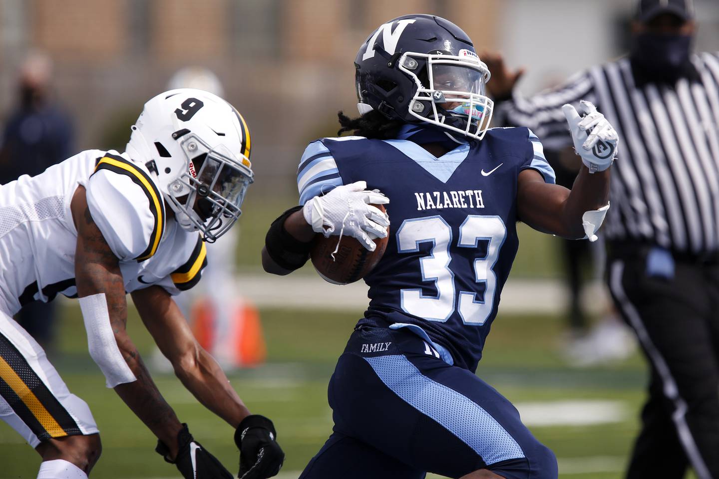 Nazareth’s Patrick Oden (right) gets past St. Laurence’s  and runs toward the end zone Aaron Wofford during their football game at Nazareth Academy in LaGrange Park, Ill., on Saturday, March 27, 2021.