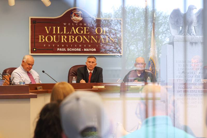 Bourbonnais Mayor Jeff Keast presides over his first board meeting on Monday, May 5, 2025, after being sworn in to the village's top seat.  The exterior of the Bourbonnais Municipal Center is reflected in the meeting room glass.