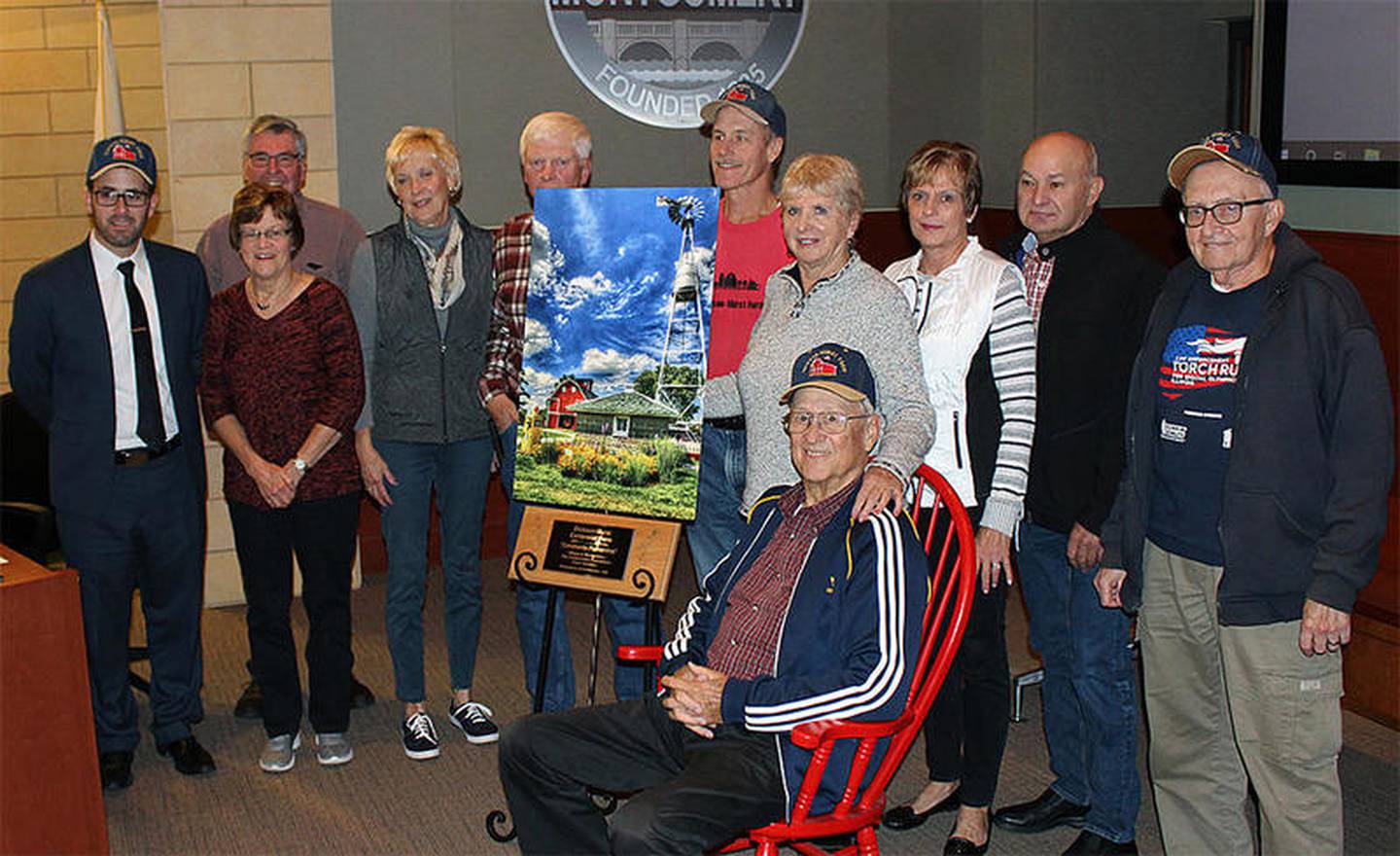 Members of the Dickson-Murst Farm Partners presented a photo of the Dickson-Murst Farm to the village of Montgomery at the Oct. 22 village meeting in appreciation of its support to preserve the historic farmstead. The farm is owned by The Conservation Foundation and the Partners maintain the farm buildings and host events to honor the area’s rich farming history. Pictured from left are Village President Matt Brolley, Neal and Jan Woessner of Oswego, Jane and Ken Wolf of Oswego, Jeff Nakaerts of Plainfield, Marian and (seated) Richard “Shorty” Dickson of Bristol, Martha and Jim Cumpata of Oswego, and Ron Curbis of Montgomery. “Shorty” Dickson grew up on the farm, which his great-grandfather bought around 1865.