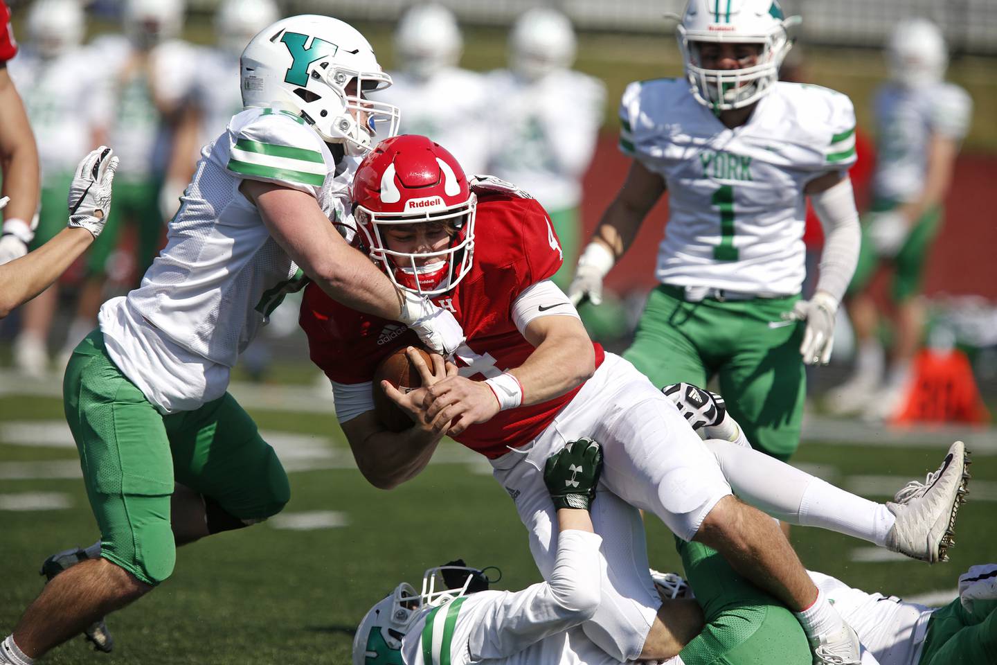York’s Jeff Coglianese (left) and Everett Snyder (bottom) tackle Hinsdale Central’s Michael Brescia during their football game at Hinsdale Central High School in Hinsdale, Ill., on Saturday, April 3, 2021.