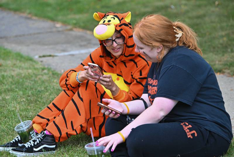 Crystal Lake Central High School students Franshaska Taylor ('24) and Amanda Kasenter ('24)' sit along the parade route to celebrate Crystal Lake Central's 100 year anniversary homecoming day on Saturday, Sep. 16, 2023 in Crystal Lake. The parade began at the high school and made its way through downtown Crystal Lake.