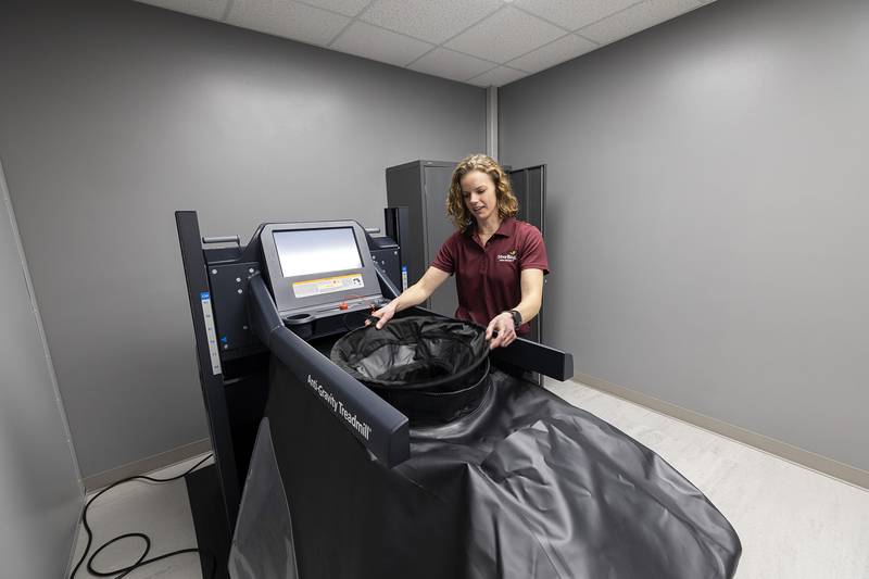 Marketing director Breanne Hunter explains how the anti-gravity treadmill works Tuesday, Jan. 31, 2023 before the ribbon cutting. The treadmill will give its users many of the benefits without the wear and tear on joints, muscles and tendons.