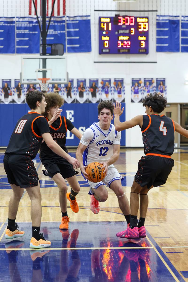 Peotone's Tyler Walker maneuvers through Beecher defenders toward the basket during the Blue Devils' 64-52 victory over Beecher on Wednesday, Jan. 28, 2026.