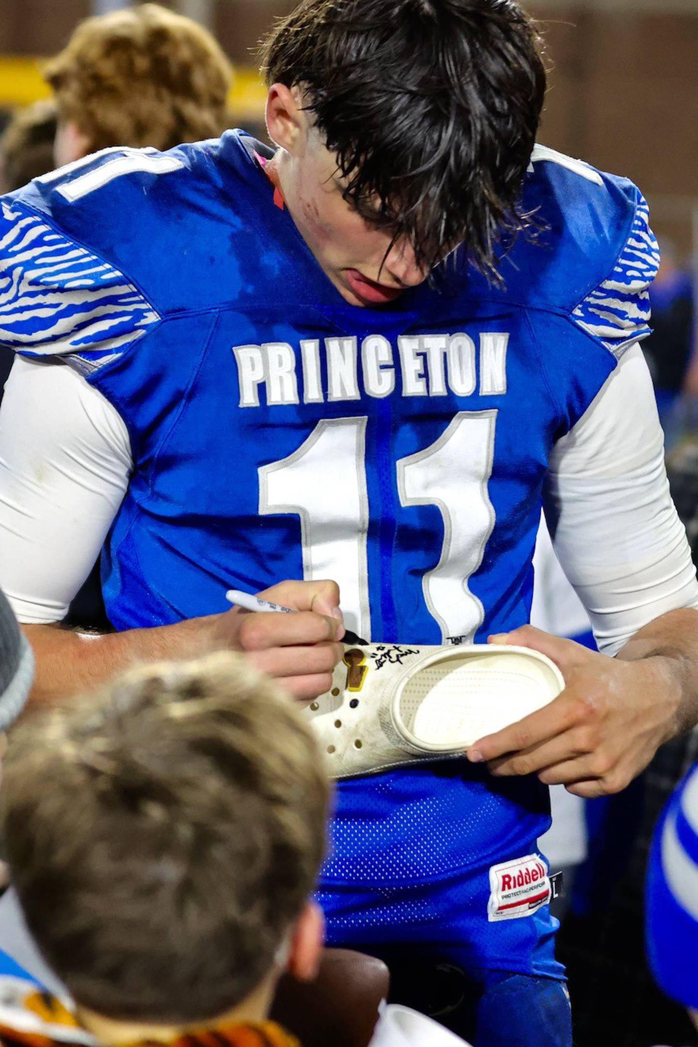 Princeton senior All-Stater Noah LaPorte signs a shoe for a young admirer after a football game last season. The future Northwestern Wildcats always drew a crowd of young admirers.