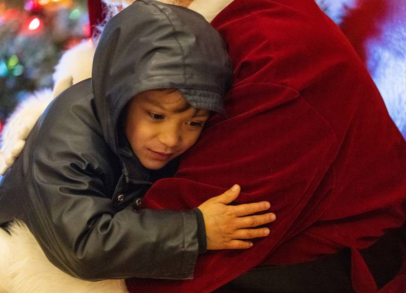 Garrison LeVrouw, 5, hugs Santa at a photo opportunity with him during the Celebration of Lights at the Batavia Riverwalk on Sunday, Dec. 1, 2024.