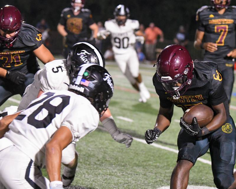 Montini Catholic's Montini's Charles Flowers (15) runs the ball while being defended by Fenwick's Mike Muprhy (5) and teammate Aiden Williams (28) during the game on Friday Sept. 19, 205, held at Montini Catholic High School.
