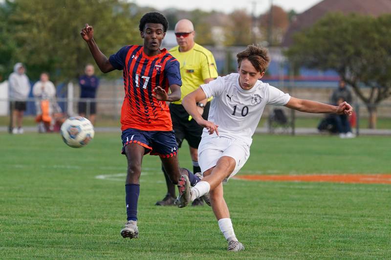 Oswego East's Dylan Drendel (10) shoots the ball against Oswego’s Thomas Marcoux (17) during a soccer match at Oswego High School on Tuesday, Oct. 1, 2024.