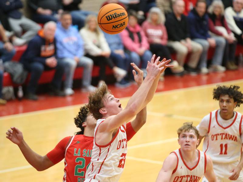 Ottawa's Owen Sanders looses control of the ball in the lane against L-P's Marion Persich on Friday, Jan. 10, 2024 in Kingman Gym at Ottawa High School.