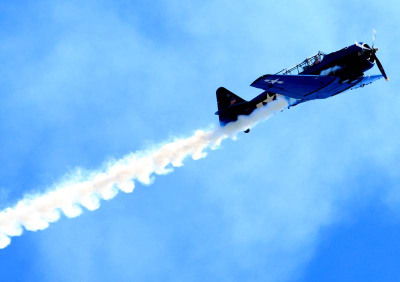 A vintage plane streams above during a Memorial Day service and parade in downtown Woodstock on Monday, May 26, 2025.