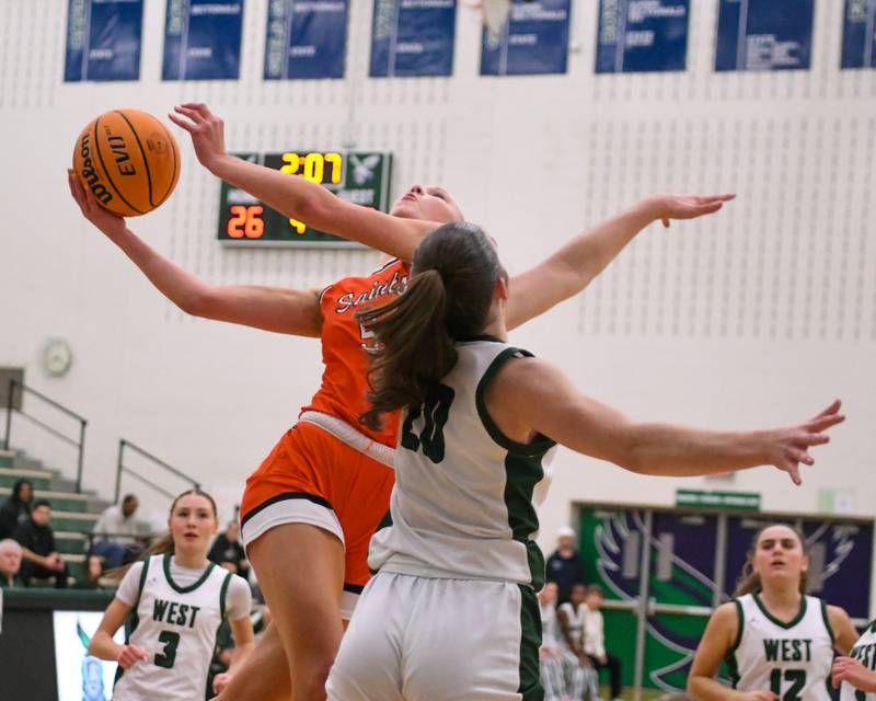 St. Charles East's Brooklyn Schilb (5) makes a basket while being defended by Glenbard West's Ellie Noble (20) during the 4A Sectional championship game on Thursday Feb. 26, 2026, held at Bartlett High School.